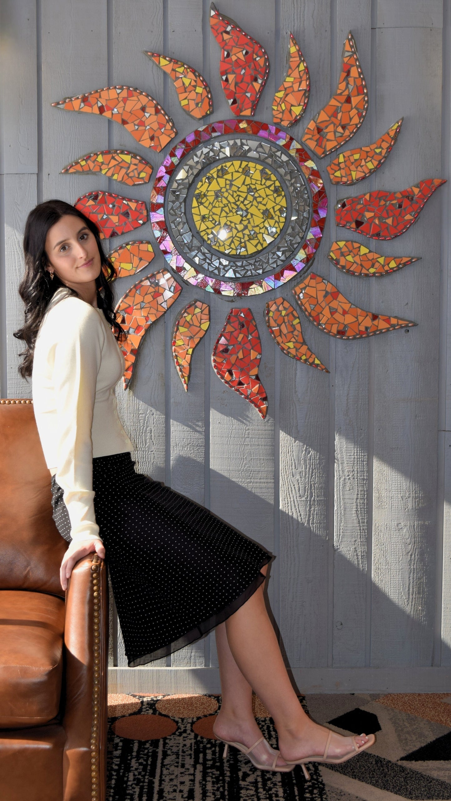 Woman wearing a button up sweater top with a black polka dot midi skirt