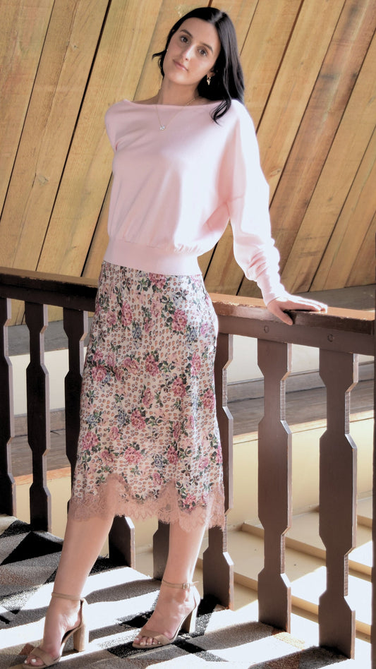 Woman wearing a floral midi skirt with a side slit and a lace hem.